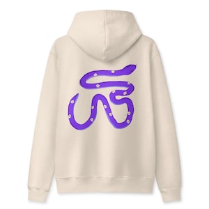 Può includere: Una felpa con cappuccio color beige che presenta sul retro una grafica raffigurante un lungo serpente viola sinuoso decorato con piccoli fiori bianchi. La felpa ha maniche lunghe, un cappuccio e un orlo a coste, vista dal retro.