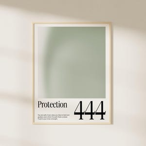 May include: A framed print with a soft green background. The word "Protection" is printed in a serif font, with the number "444" in a bold sans-serif font. Below the text is a quote about safety and inner strength.