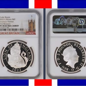 Peut inclure: Deux pièces de monnaie britanniques encastrées. L'une représente un lion et le texte "Lion of England" et "2022". L'autre montre le profil de la reine Elizabeth II et le texte "2 Pounds". Le fond est un drapeau britannique.