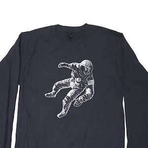 May include: A dark blue long-sleeved t-shirt with a white graphic of an astronaut floating in space.