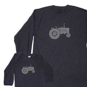 Pu&ograve; includere: Una maglietta a maniche lunghe blu navy e un body per neonato blu navy con un grafico di trattore grigio.