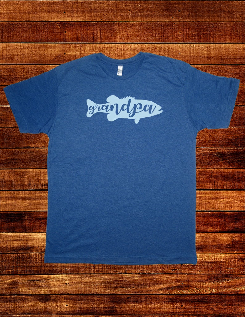 May include: A blue t-shirt with a light blue silhouette of a fish with the word "grandpa" written inside the fish.
