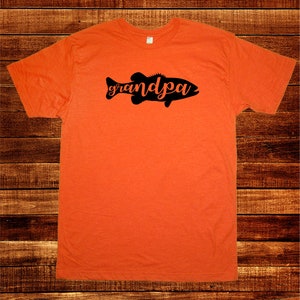 May include: Orange t-shirt with a black silhouette of a fish with the word "grandpa" written inside the fish.