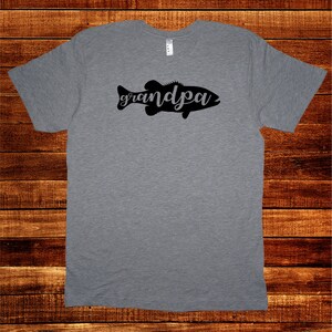 May include: A heather grey t-shirt with a black silhouette of a fish with the word "grandpa" written inside the fish.