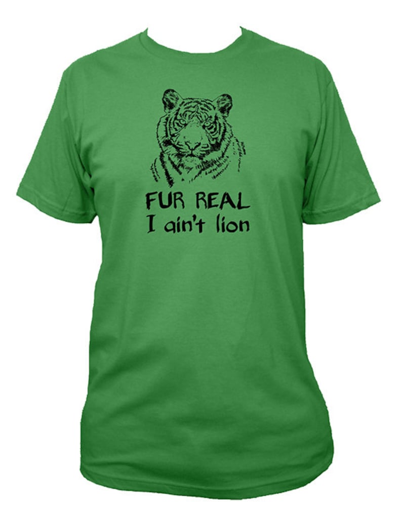 May include: Green t-shirt with a black and white illustration of a tiger's face and the text "FUR REAL I ain't lion".