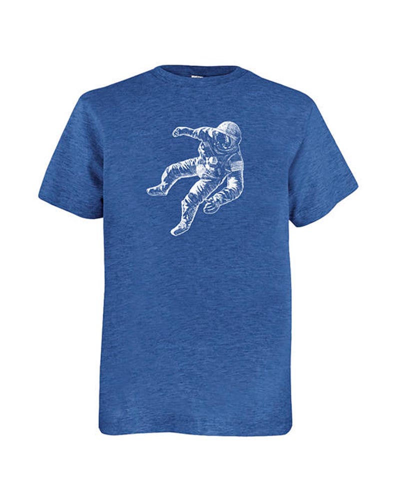 May include: Blue crew neck t-shirt featuring a white graphic of an astronaut in a spacesuit. The astronaut is depicted floating. The t-shirt is made of a soft, comfortable material.
