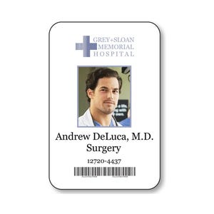 May include: A white rectangular identification badge featuring the Grey+Sloan Memorial Hospital logo, a portrait of Andrew DeLuca, M.D., the text Surgery, the number 12720-4437, and a black barcode at the bottom with the numbers A1234567890 below it.