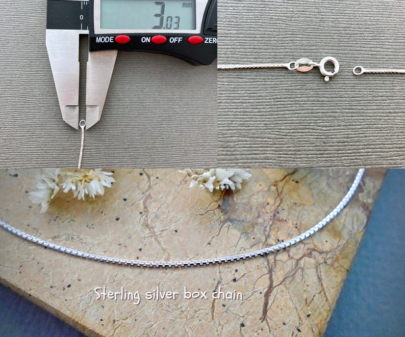 May include: A close-up of a silver box chain necklace. The chain is 3.03 mm wide. The necklace is on a light brown surface.