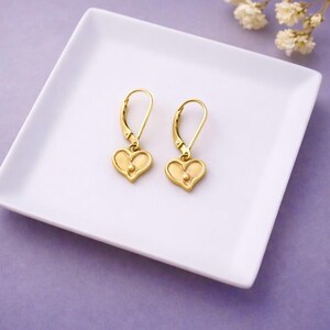Dainty Heart Earrings Gold Vermeil Heart Charm Leverback Design Minimalist Jewelry Style Tiny Heart Pendant Polished Surface Finish Everyday Wear Accessory Simple Elegant Look Birthday Gift Idea Girlfriend Present Special Occasion Jewelry