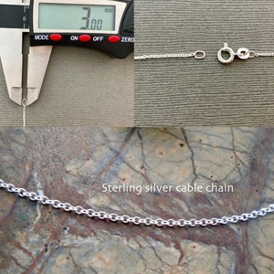 May include: Close-up of a silver cable chain necklace measured at 3.00 mm in width. The chain is on a textured surface. Sterling silver cable chain.