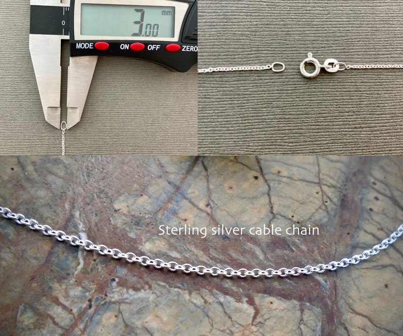 May include: Close-up of a silver cable chain necklace measured at 3.00 mm in width. The chain is on a textured surface. Sterling silver cable chain.