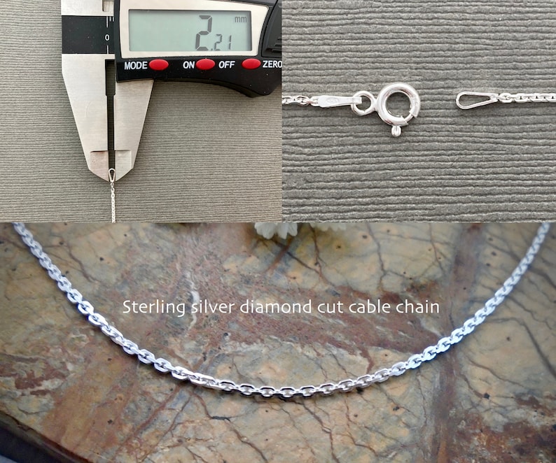 May include: A close-up of a silver diamond cut cable chain necklace. The chain is 2.21 mm wide and is shown next to a ruler. The chain is also shown laid out on a textured surface.