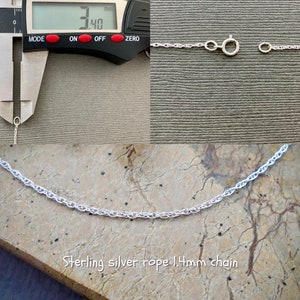 May include: Close-up of a silver rope chain measuring 1.4mm in width. The chain is shown on a wooden surface and is being measured with a caliper. The caliper reads 1.40mm.