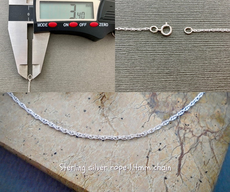 May include: Close-up of a silver rope chain measuring 1.4mm in width. The chain is shown on a wooden surface and is being measured with a caliper. The caliper reads 1.40mm.