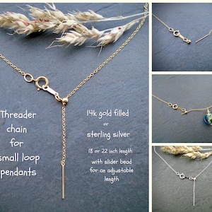 May include: A gold-filled or sterling silver chain necklace with a slider bead for adjustable length. The chain is designed to thread small loop pendants. The text on the image reads: "Threader chain for small loop pendants 14k gold filled or sterling silver 18 or 22 inch length with slider bead for an adjustable length"