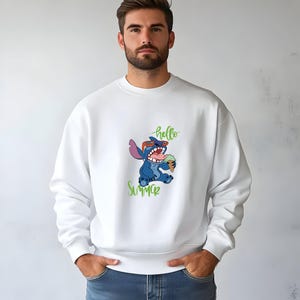 Puede incluir: Sudadera blanca con un personaje de dibujos animados Stitch con gafas de sol y un helado. Las palabras "hello" y "Summer" est&aacute;n escritas en verde. La sudadera es de estilo casual y c&oacute;modo.