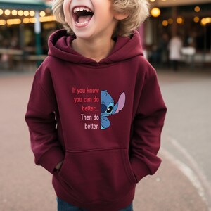 Puede incluir: Sudadera con capucha burdeos con bolsillo delantero y capucha. La sudadera con capucha presenta un gr&aacute;fico de Stitch de Lilo & Stitch, junto con el texto "If you know you can do better... Then do better."