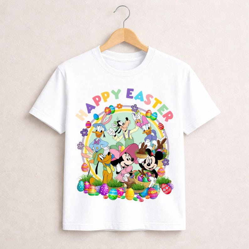 May include: White t-shirt featuring a colorful graphic of Disney characters celebrating Easter. The design includes Mickey and Minnie Mouse, Donald and Daisy Duck, Goofy, and Pluto, surrounded by Easter eggs and the words "Happy Easter."
