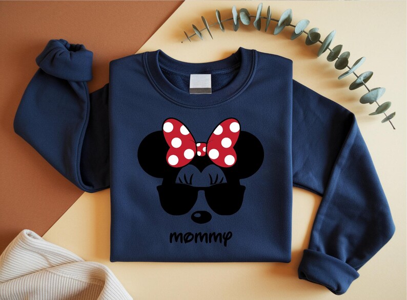 Może przedstawiać: Granatowa bluza z nadrukiem Myszki Minnie w okularach przeciwsłonecznych i czerwoną kokardą w białe grochy. Słowo "mommy" jest wydrukowane poniżej. Codzienna g&oacute;ra.