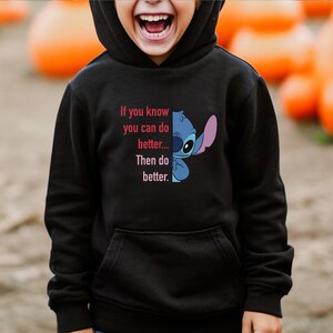 Puede incluir: Sudadera con capucha negra con un gr&aacute;fico de Stitch y el texto "If you know you can do better... Then do better." El dise&ntilde;o presenta colores azul, rosa y blanco. La sudadera tiene un bolsillo delantero y una capucha.