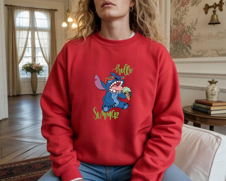 Puede incluir: Sudadera roja con un personaje de dibujos animados azul con gafas de sol y helado. Las palabras "hello Summer" est&aacute;n escritas en verde y amarillo. La sudadera es de color rojo liso.