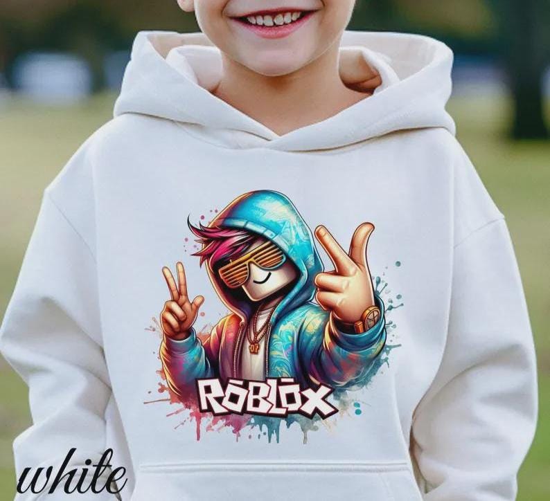 Puede incluir: Sudadera con capucha blanca con un gr&aacute;fico colorido de un personaje con gafas de sol y la palabra "ROBLOX". El gr&aacute;fico tiene una combinaci&oacute;n de colores azul, rosa y naranja. La palabra "white" est&aacute; impresa en la parte inferior izquierda.