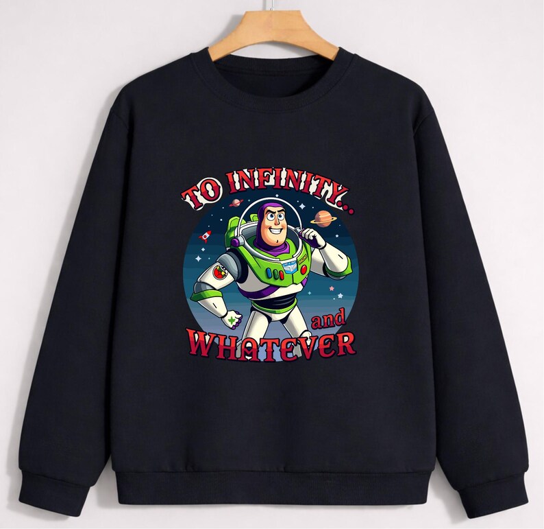 Op de afbeelding: Zwarte sweatshirt met een afbeelding van Buzz Lightyear uit Toy Story. Het ontwerp bevat de zin "TO INFINITY... and WHATEVER" in een kleurrijk, gestileerd lettertype. Buzz is afgebeeld in zijn ruimte ranger pak.