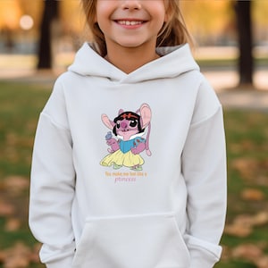 May include: White hooded sweatshirt featuring a cartoon character in a princess dress. The character is pink with large ears and a black hairpiece. The text "You make me feel like a princess" is printed below the character.
