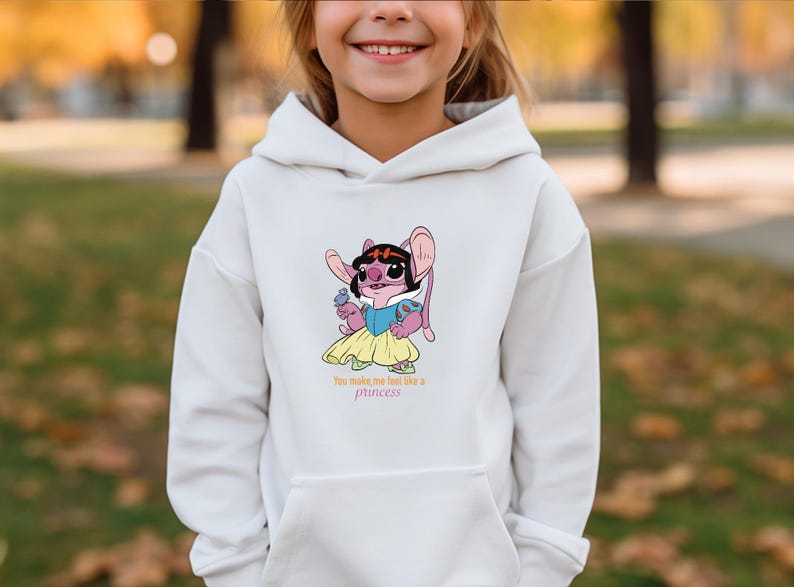 May include: White hooded sweatshirt featuring a cartoon character in a princess dress. The character is pink with large ears and a black hairpiece. The text "You make me feel like a princess" is printed below the character.