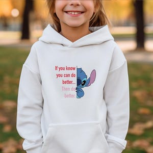 Puede incluir: Sudadera con capucha blanca con un personaje de dibujos animados azul y el texto "If you know you can do better... Then do better." El personaje tiene ojos grandes y una oreja grande. La sudadera tiene un bolsillo delantero.