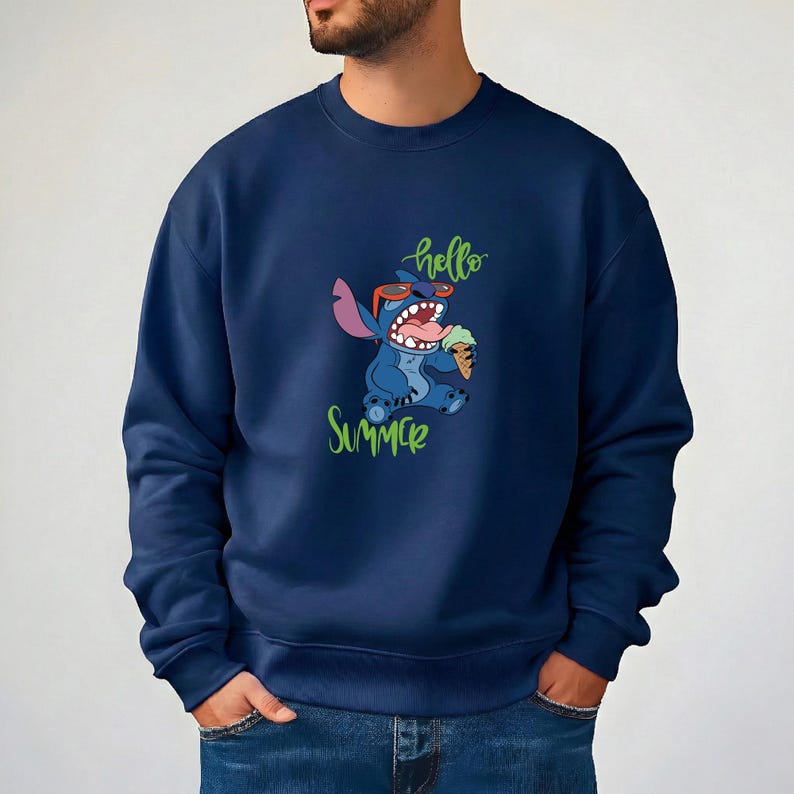 Puede incluir: Sudadera azul marino con un dise&ntilde;o de Stitch, un personaje de dibujos animados, con gafas de sol y un helado. Las palabras "hello summer" est&aacute;n escritas en verde. La sudadera es de color liso.