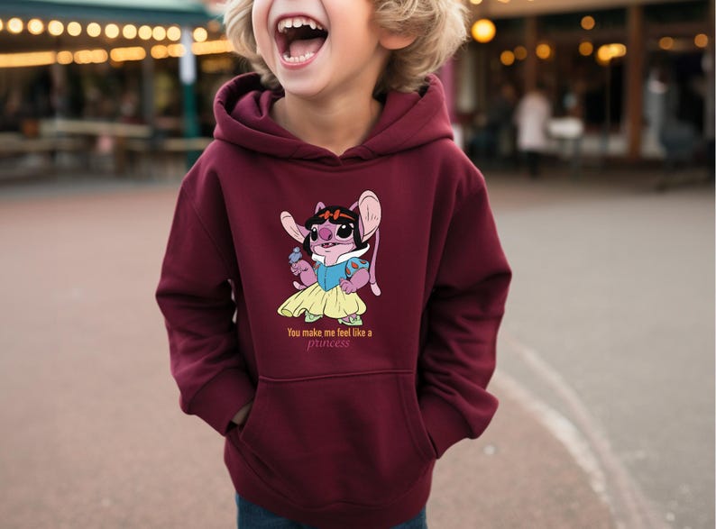 May include: Burgundy hoodie with a cartoon graphic of a character dressed as a princess. The graphic includes the text "You make me feel like a princess". The hoodie has a front pocket and a hood.