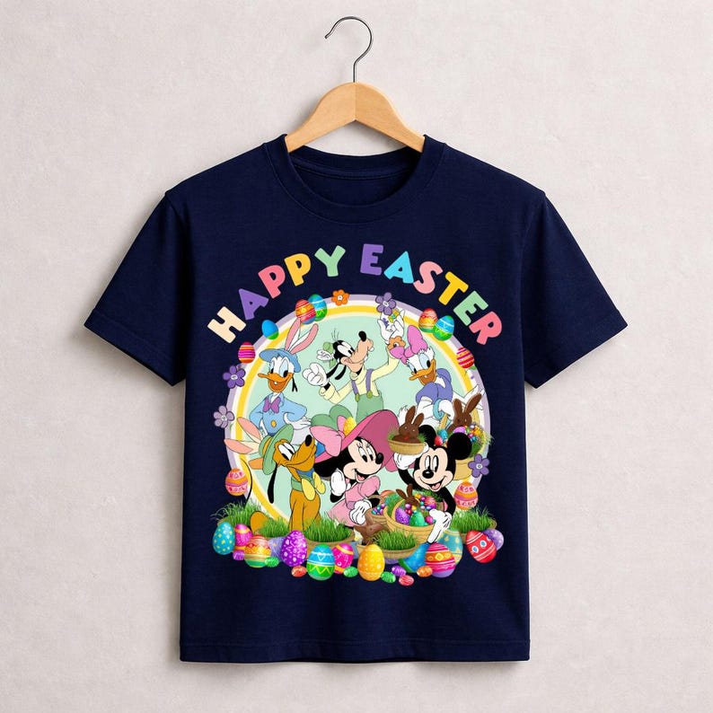 May include: Navy blue t-shirt featuring a colorful graphic of Disney characters, including Mickey and Minnie Mouse, Donald Duck, and Goofy, with the text "HAPPY EASTER". The design includes Easter eggs and flowers.