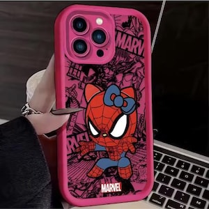 May include: Pink phone case featuring a cartoon Spider-Man character with a cat-like face and a blue bow. The case has a pink border and a Marvel logo. The background has a comic book style design.