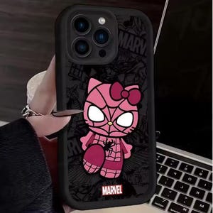 May include: Black phone case featuring a pink cartoon character with a spiderweb design and a bow. The case has a Marvel logo at the bottom. The background has a comic book style design.
