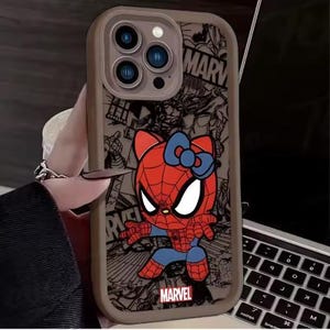 May include: A phone case featuring a cartoon character that is a hybrid of Spider-Man and Hello Kitty. The case has a brown border and a comic book style background with the Marvel logo. The character is red, blue, and white.