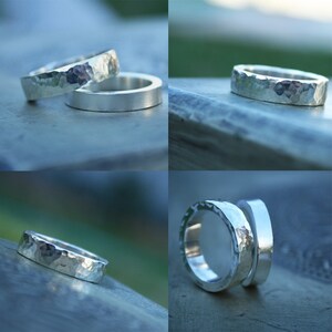 May include: Two silver hammered rings, one stacked on top of the other. The rings are both wide and have a textured surface.