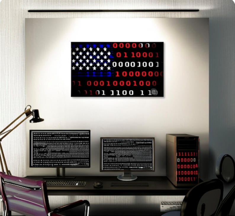 Puede incluir: Una impresi&oacute;n de arte digital de la bandera estadounidense, representada en c&oacute;digo binario, cuelga sobre un escritorio con dos monitores de computadora y una computadora de escritorio. Las estrellas y las rayas de la bandera est&aacute;n representadas por d&iacute;gitos binarios blancos y rojos.