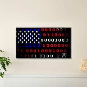 Puede incluir: Una obra de arte enmarcada que representa la bandera estadounidense, representada en un estilo de c&oacute;digo binario digital. Las estrellas y las rayas de la bandera est&aacute;n representadas con estrellas blancas, d&iacute;gitos binarios rojos y azules y un fondo negro.