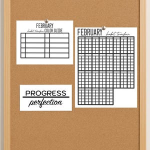 Pode incluir: Um quadro de cortiça com moldura de madeira exibe três folhas de papel branco. A folha superior esquerda diz "FEBRUARY habit tracker COLOR GUIDE" com uma grade. A folha superior direita é um rastreador de hábitos para fevereiro. A folha inferior diz "PROGRESS perfection."
