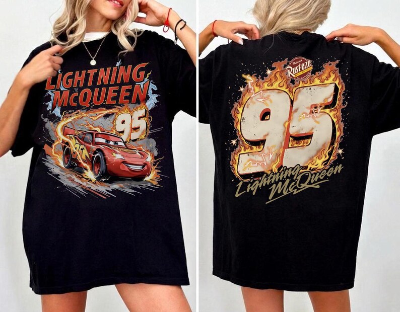 Puede incluir: Camiseta negra con un dise&ntilde;o de Rayo McQueen de la pel&iacute;cula Cars. El frente muestra a McQueen con el n&uacute;mero 95, y la parte trasera presenta el n&uacute;mero 95 entre llamas, con el texto "Lightning McQueen".