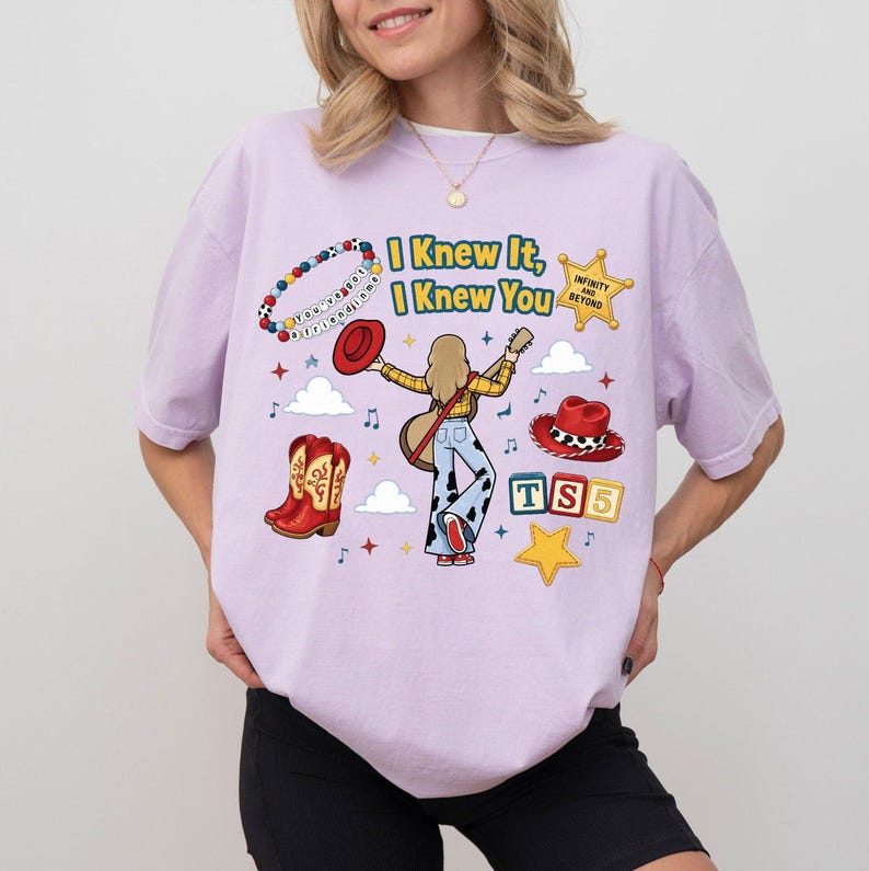 Peut inclure: Un t-shirt violet clair avec une impression graphique portant le texte I Knew It, I Knew You, un bracelet de perles, une &eacute;toile jaune, des bottes de cow-boy rouges, un chapeau rouge, un personnage jouant de la guitare et des blocs TS5.