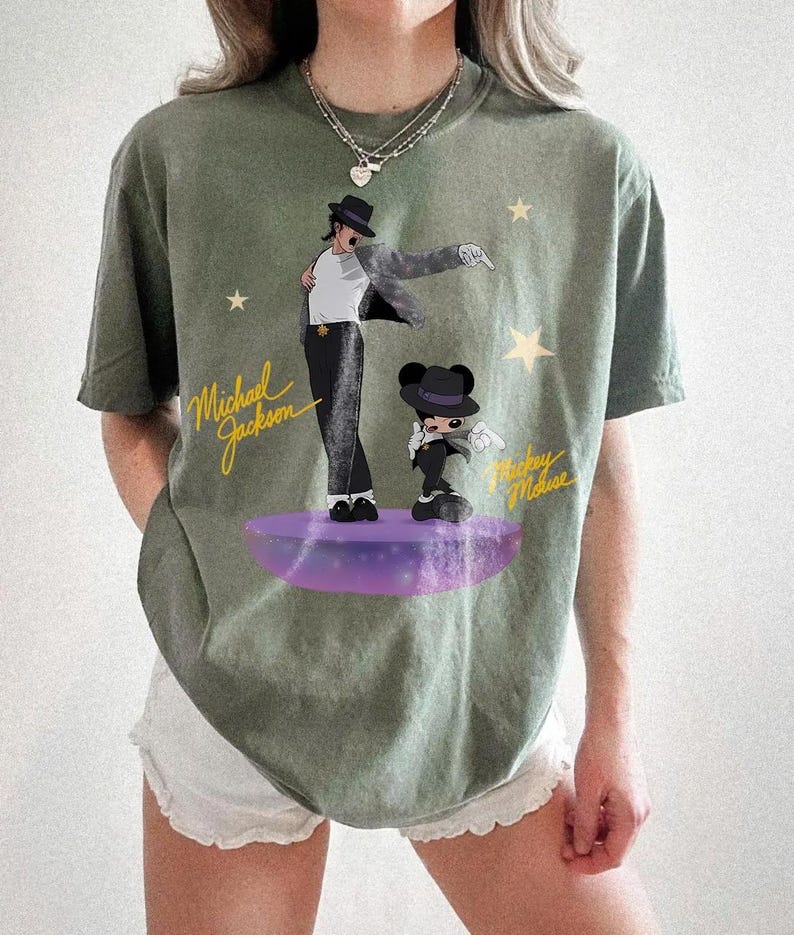 Puede incluir: Camiseta verde oliva con un gr&aacute;fico de Michael Jackson y Mickey Mouse sobre una plataforma morada. El dise&ntilde;o incluye el texto "Michael Jackson" y "Mickey Mouse" en escritura amarilla, con acentos de estrellas.