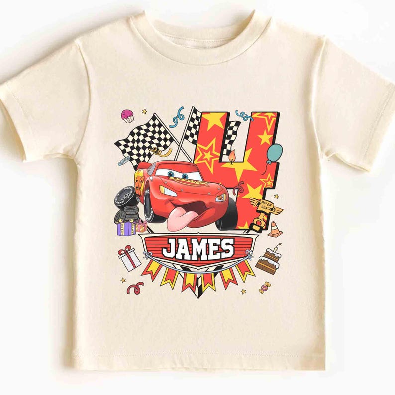 May include: Cream-colored t-shirt featuring a red race car graphic with the number 4, stars, and checkered flags. The name "JAMES" is displayed on a banner below the car. Birthday-themed design.