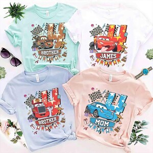 May include: Four t-shirts in pastel colors: mint, white, light blue, and pink. Each shirt features a cartoon car graphic with the number 4 and the words "Brother", "James", "Brother", and "Mom". Checkered flags and birthday cake graphics are also included.
