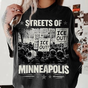 May include: Black t-shirt with the text "STREETS OF MINNEAPOLIS" and a graphic of a protest with signs that say "ICE OUT!". The shirt has a vintage, distressed look.