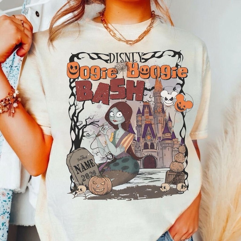 May include: Cream-colored t-shirt featuring a graphic for the Disney Oogie Boogie Bash. The design includes Sally from The Nightmare Before Christmas, a haunted castle, pumpkins, and the text "Oogie Boogie Bash".