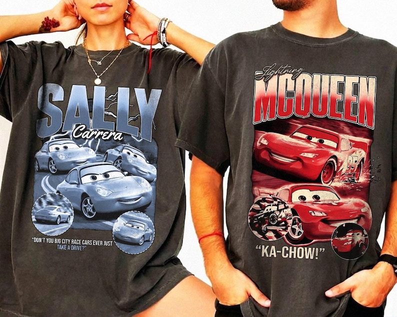 Puede incluir: Dos camisetas gris carb&oacute;n con gr&aacute;ficos de la pel&iacute;cula Cars. Una camiseta muestra "SALLY Carrera" con im&aacute;genes de un coche azul claro. La otra camiseta muestra "Lightning McQueen" con ilustraciones de coches rojos y la frase "KA-CHOW!"