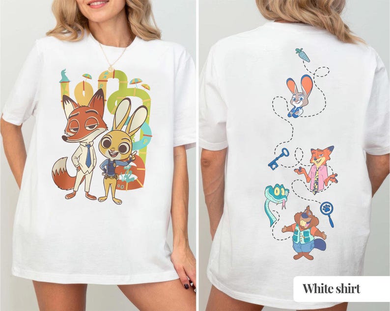 May include: White t-shirt featuring a cartoon illustration of a fox and a rabbit. The front of the shirt displays the characters in a colorful design. The back of the shirt has additional cartoon characters and the text "White shirt".