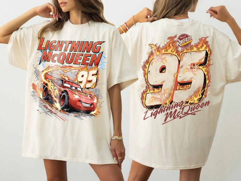 Puede incluir: Camiseta color crema con Lightning McQueen de la pel&iacute;cula Cars. El gr&aacute;fico frontal muestra a McQueen corriendo con el texto "Lightning McQueen 95". La parte trasera muestra un gran "95" en llamas con "Lightning McQueen" debajo.